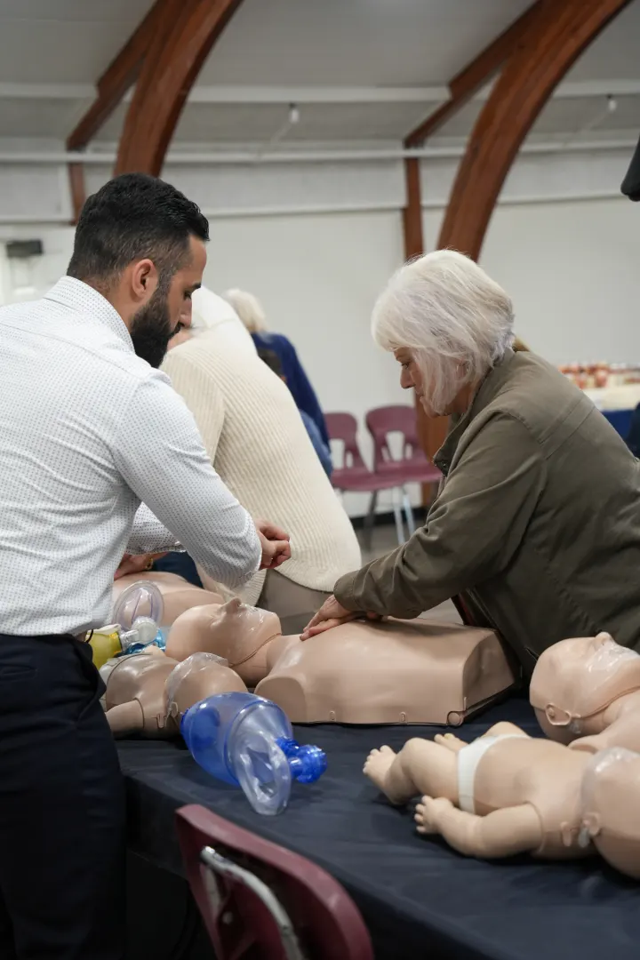 A guest practises chest compressions on a manikin