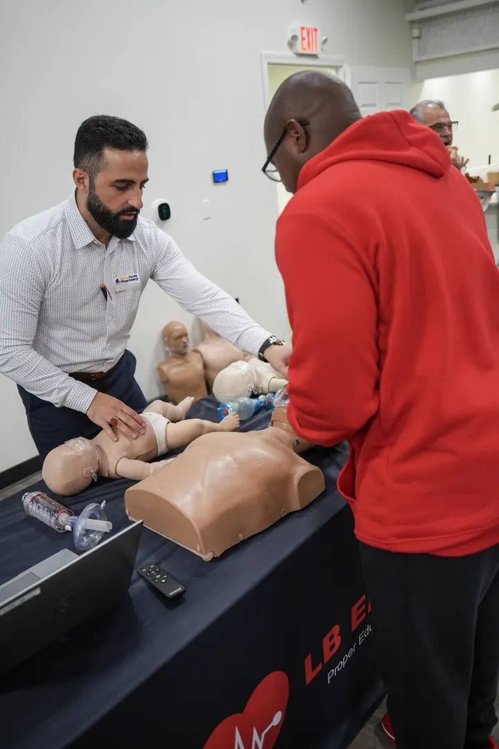 Showing a guest how to give CPR to an infant manikin